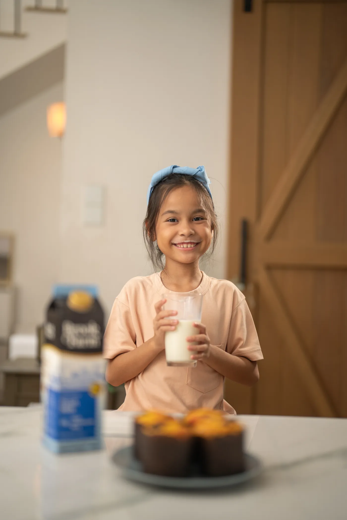 A child smiling over a fresh glass of milk