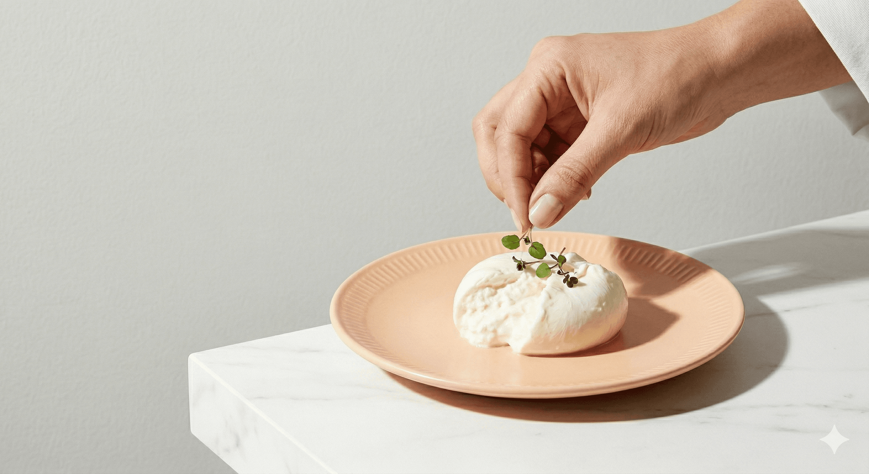Fresh burrata being garnished by a chef
